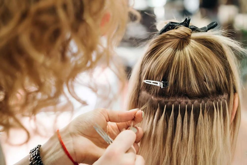 Hair extensions being applied — Avenue Salon Plano TX